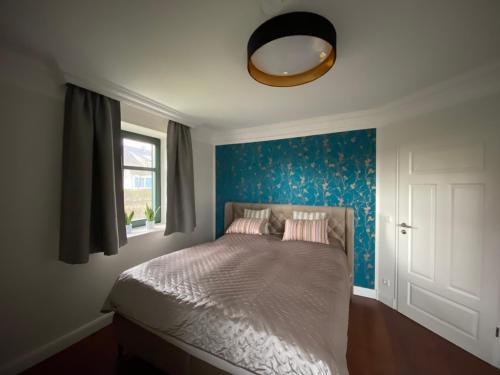 a bedroom with a bed with a blue wall at Ferienwohnung Groß Zicker in Groß Zicker