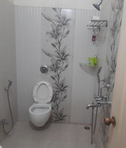 uma casa de banho com um WC com um padrão de flores na parede em Premanand's House em Raipur