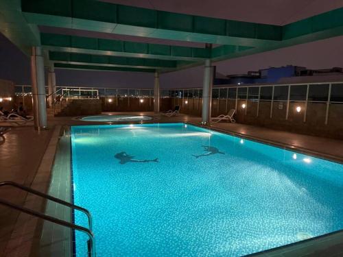 a swimming pool on top of a building at night at Newly Furnished Studio in Elite in Dubai