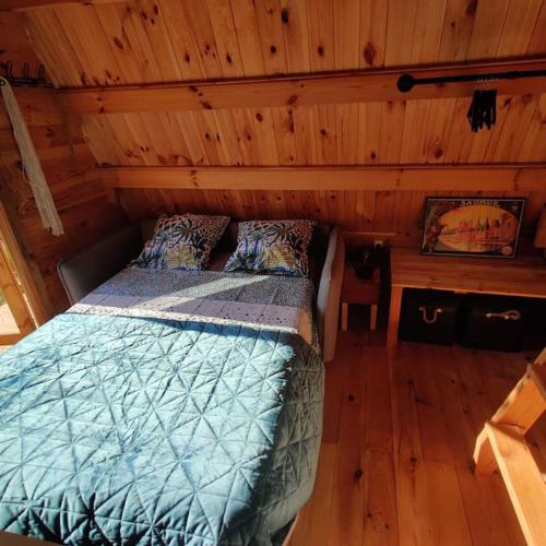 a bedroom with a bed in a log cabin at Tipi Apache des monteaux in Vivy