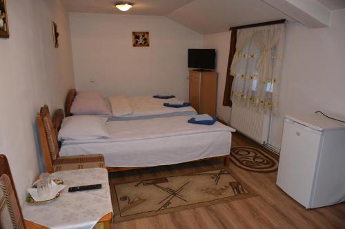 a small room with two beds and a table at Pensiunea Poiana in Borşa