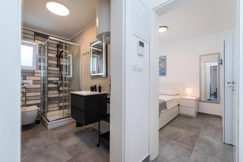 a bathroom with a sink and a shower and a bed at Infinity Dalmatia Apartments in Vinjerac