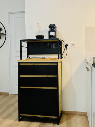 une armoire noire et jaune avec une bouilloire au-dessus dans l'établissement Canyon et Bali Studio centre Valence, à Valence