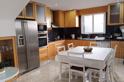 uma cozinha com uma mesa branca e um frigorífico em Casa Monte Ponta do Sol SeaViews em Ponta do Sol