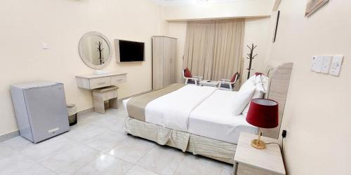 Habitación de hotel con cama y espejo en Pearl Hotel Apartment - اللؤلؤ للشقق الفندقية, en Al Buraymī