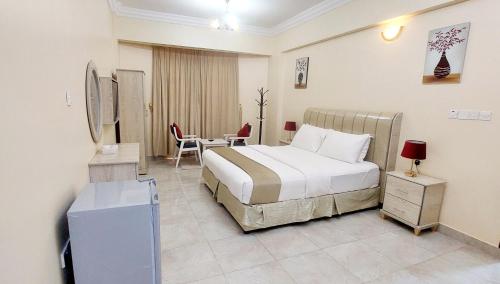 um quarto de hotel com uma cama, uma mesa e cadeiras em Pearl Hotel Apartment - اللؤلؤ للشقق الفندقية em Al Buraimi