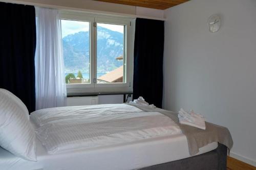 sypialnia z białym łóżkiem i oknem w obiekcie Mariposa Spiez w mieście Spiez