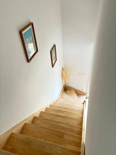 un escalier avec deux photos sur le mur et un escalier. dans l'établissement La casa Rogatienne, à deux pas de La Rochelle, à Saint-Rogatien