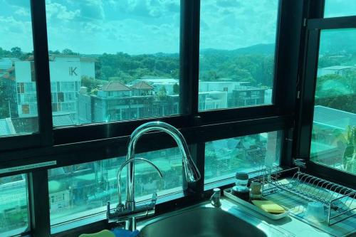 a kitchen sink with a view of a city at Corner Smart Home Condo Amazing Views of Chiang Mai, Doi Suthep, and Nimman in Chiang Mai