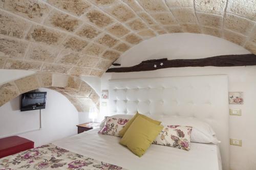 a bedroom with a white bed with a stone ceiling at Le Caravelle Bed and Breakfast in Monopoli