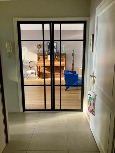 リヨンにあるJunior suite avec balconのベッドルーム1室の景色を望むガラスのスライドドアが備わる客室です。