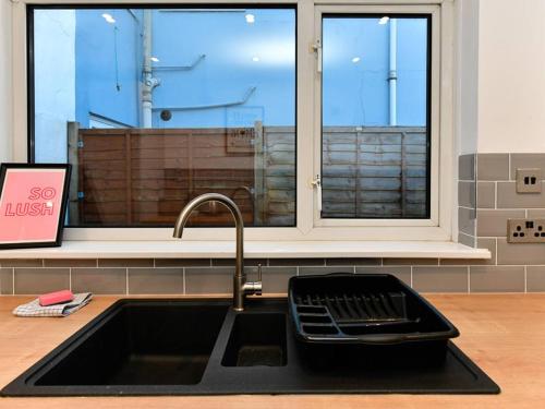 ein Waschbecken in einer Küche mit Fenster in der Unterkunft Pass the Keys Cosy 2 bed home in Pontcanna in Cardiff