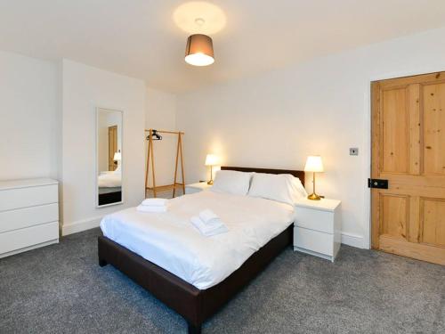 ein Schlafzimmer mit einem großen Bett und einer Holztür in der Unterkunft Pass the Keys Cosy 2 bed home in Pontcanna in Cardiff