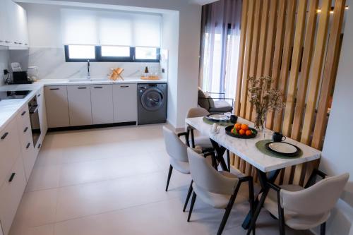 a kitchen and dining room with a table and chairs at Mi casa su casa in Néa Koútali
