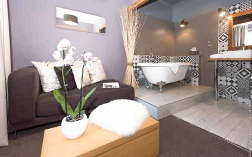 a living room with a couch and a bath tub at Logis Hôtel La Magnanerie - Côté Bistro in Aubignosc