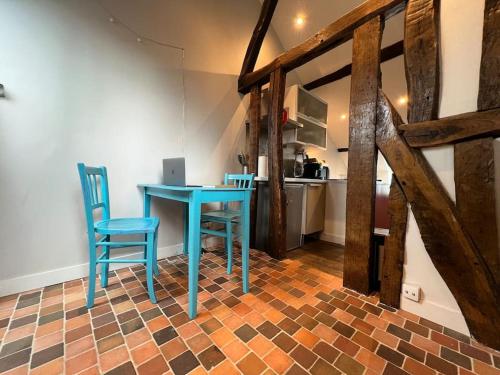 une table bleue et deux chaises dans une pièce dans l'établissement rhoazon heart, à Rennes