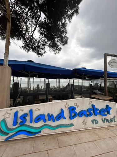 a sign for a beach bar with a blue umbrella at Artemis Beach Holiday Nest 1 in Artemida