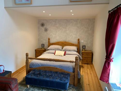 een slaapkamer met een houten bed in een kamer bij Chez Helen in Marsac