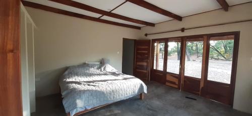 Schlafzimmer mit einem Bett und einer Glasschiebetür in der Unterkunft Adansonia Farm 