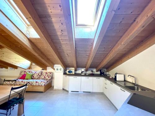 eine Küche und ein Wohnzimmer mit einem Sofa und einem Fenster in der Unterkunft Ledrobenessere in Pieve Di Ledro
