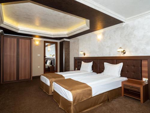 Un pat sau paturi într-o cameră la Hotel Elit