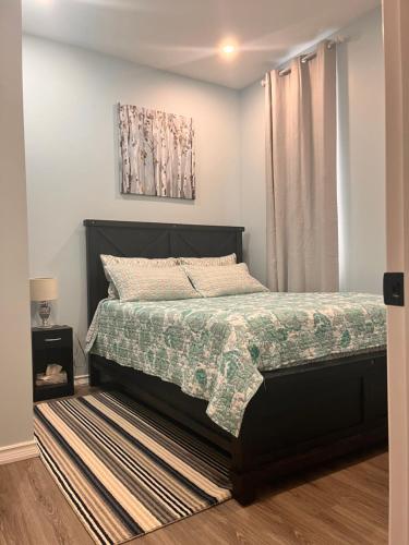 a bedroom with a bed with a green comforter at Private Apartment/Suite in Whitby