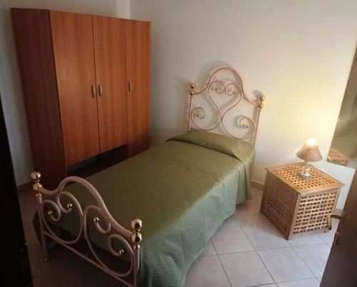 a bedroom with a bed and a wooden cabinet at Le Casette di Prissy in Rignano Flaminio