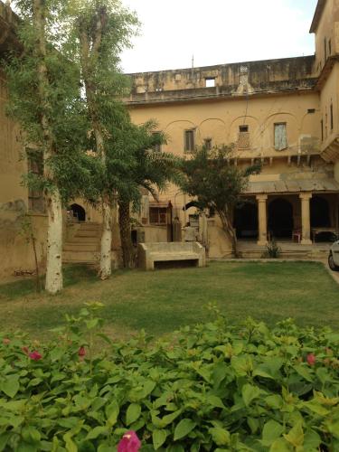 an old building with a yard with flowers at Narayan Niwas Castle in Rāmgarh