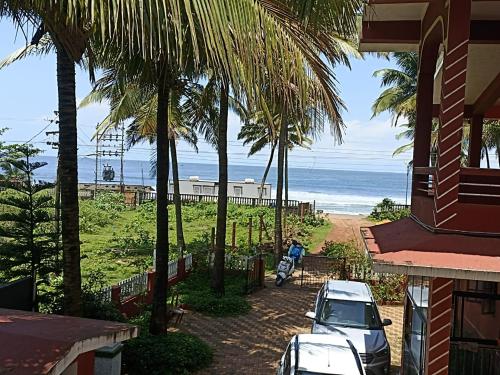 een uitzicht op het strand vanuit een huis met palmbomen bij LEON HOME STAY in Bogmalo