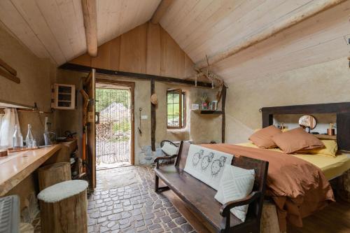 1 dormitorio con cama y techo de madera en Cabanots - Ecolodges en Vallée d'Ossau à 900m d'altitude, 