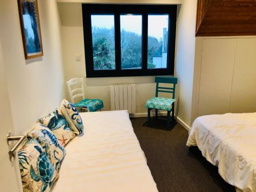 a bedroom with two beds and a window at Villa Tidinghi, plage de Rospico à pied in Névez