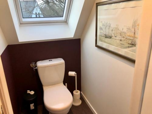 a bathroom with a toilet and a picture on the wall at Villa Tidinghi, plage de Rospico à pied in Névez
