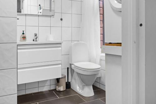 a white bathroom with a toilet and a sink at Peaceful Urban Residence in Bergen