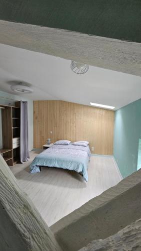 une chambre avec un grand lit dans une pièce dans l'établissement Coliv'Castres, à Burlats