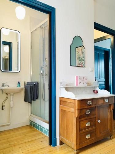 une salle de bain avec un lavabo, une douche et un miroir dans l'établissement Maison de Vacances 1930, à Vannes