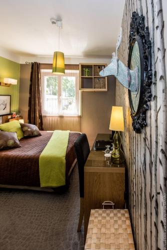 une chambre avec un lit et une horloge au mur dans l'établissement Logis Hôtel La Magnanerie - Côté Bistro, à Aubignosc