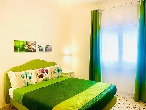 Un dormitorio con una cama verde y una ventana en Floral Holiday, en Minori