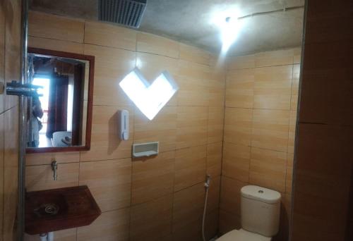 a bathroom with a toilet with a heart sign on the wall at Astradana Hotel & Glamping in Kintamani