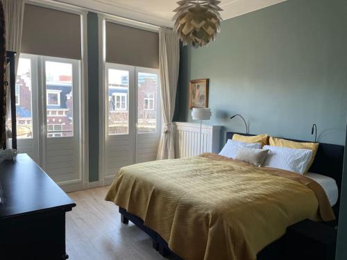 a bedroom with a bed and a large window at Luxurious top apartment near beach, musea & Keukenhof in The Hague