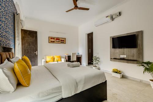 a bedroom with a large white bed with yellow pillows at Lime Tree Service Apartment Golf Course Road, Gurgaon in Gurgaon