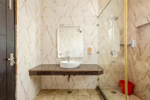 La salle de bains est pourvue d'un lavabo et d'un miroir. dans l'établissement Lime Tree Service Apartment Golf Course Road, Gurgaon, à Gurgaon