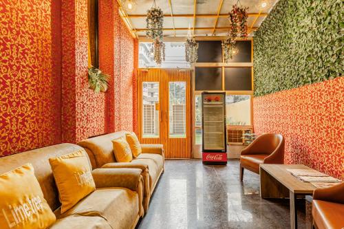 a living room with orange walls and couches at Lime Tree Service Apartment Golf Course Road, Gurgaon in Gurgaon