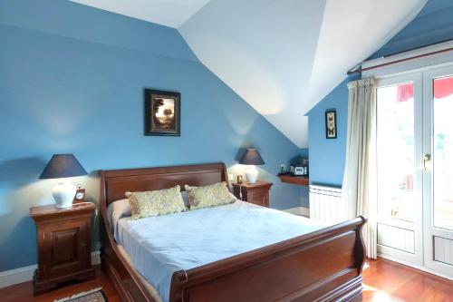 1 dormitorio con 1 cama con paredes azules en Duplex Playa Berria, en Piedrahita