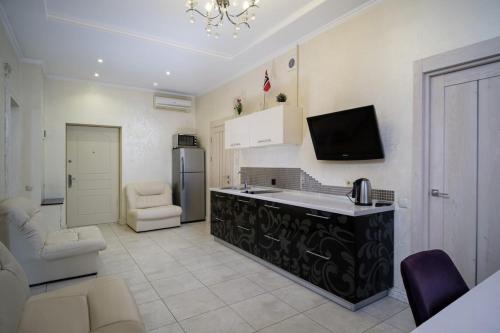 a kitchen with a refrigerator and a tv on the wall at 2 Bedrooom In CENTER Всегда есть свет ! in Odesa
