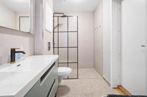 une salle de bain blanche avec toilettes et douche dans l'établissement Elegant Urban Apartment, à Bergen