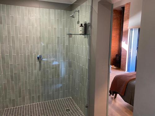 Łazienka z prysznicem wyłożona jest zielonymi kafelkami. w obiekcie Kileen Cottage w mieście Nottingham Road