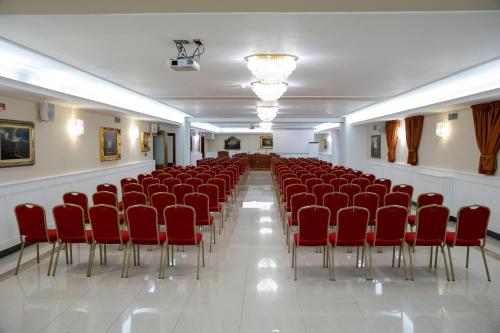 an empty room with red chairs and a white floor at Bel Sito Hotel Due Torri in Manocalzati