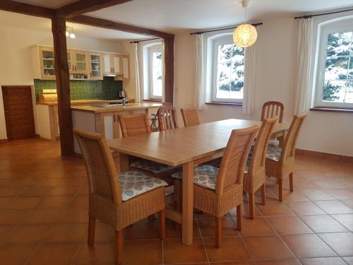 a kitchen and dining room with a wooden table and chairs at Chalupa v Českém lese in Bělá nad Radbuzou