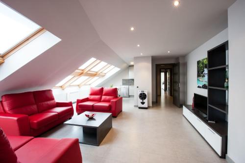 a living room with red couches and a tv at WinTuWin Apartments in Rialp