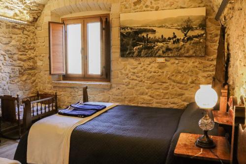 - une chambre avec un lit dans un mur en pierre dans l'établissement Mas Manosa, à Vilademuls